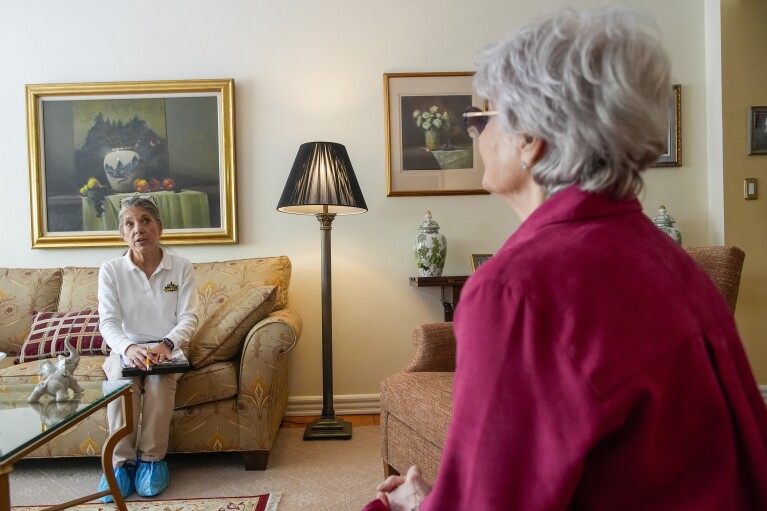 Dr. Amy Attas, left, talks with Lisa Healey a<em></em>bout Cody Healey, an 8 year old male Maltese's, symptoms during a house call, Tuesday, April 23, 2024, in New York. (AP Photo/Mary Altaffer)