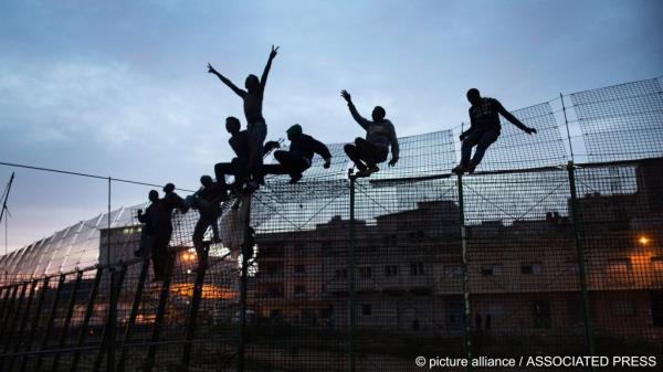From file: Sub-Saharan migrants climb over a me<em></em>tallic fence that divides Morocco and the Spanish enclave of Melilla on Friday, March 29, 2014 | Photo: Santi Palacios / AP Photo / picture alliance