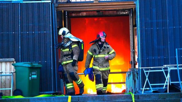Firefighters walk out of the main entrance as the Old Stock Exchange burns in Copenhagen, Denmark.</p>
<p> Pic: Scanpix/AP