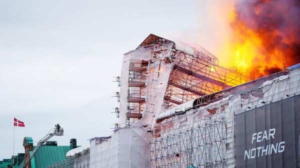 A firefighter works as fire burns at the Old Stock Exchange, Boersen, in Copenhagen, Denmark.</p>
<p> Pic: Reuters