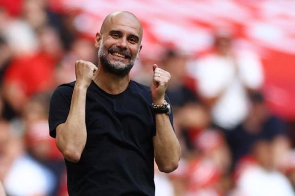 Pep Guardiola raises arms in front of his chest.