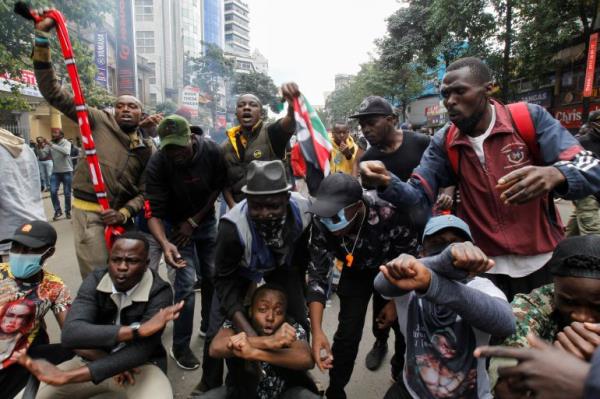 People gesture as they take part in a demo<em></em>nstration over police killings of people protesting against Kenya's proposed finance bill