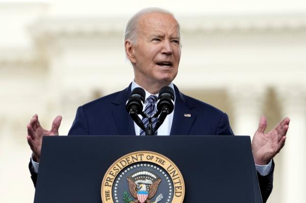 President Joe Biden speaks while standing in front of a podium