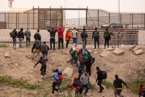Migrants try to cross through border barriers in El Paso, Texas