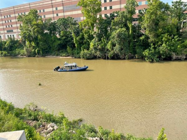 Police boat scouring the Buffalo Bayou. 