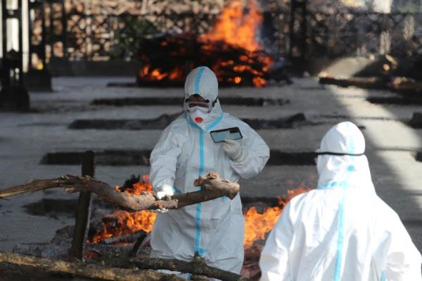 A family member performs the last rites for a COVID-19 victim at a crematorium in Jammu, India, Friday, April 23, 2021. India’s underfunded health system is tattering as the world’s worst coro<em></em>navirus surge wears out the nation, which set another global record in daily infections for a second straight day with 332,730. India has co<em></em>nfirmed 16 million cases so far, second o<em></em>nly to the United States in a country of nearly 1.4 billion people. (AP Photo/Channi Anand)