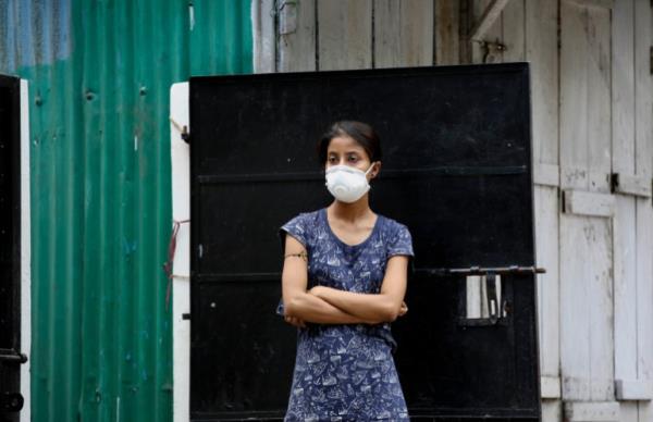 A woman watches health workers pick up relative who has been diagnosed as COVID-19 in Gauhati, India, Saturday, July 4, 2020. India's number of coro<em></em>navirus cases passed 600,000 on Thursday with the nation's infection curve rising and its testing capacity being increased. More than 60% of the cases are in the worst-hit Maharashtra state, Tamil Nadu state, and the capital territory of New Delhi. (AP Photo/Anupam Nath)