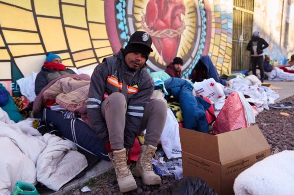 Migrants sleep outside of an overnight shelter at Sacred Heart Church on December 23 in El Paso, Texas.