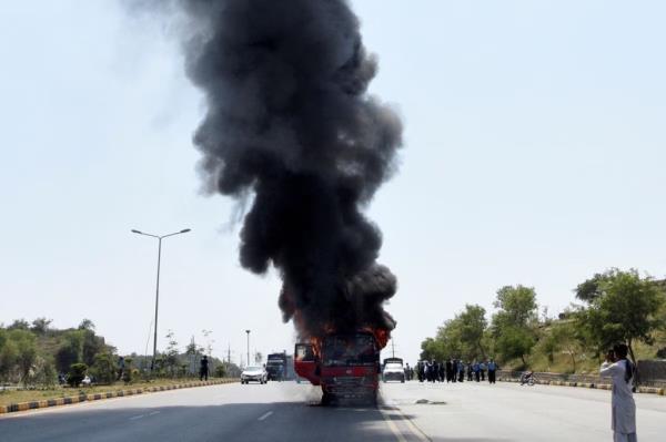 Fire and smoke billows from a bus after it caught a fire during clashes between police and supporters of Pakistan's former Prime Minister Imran Khan