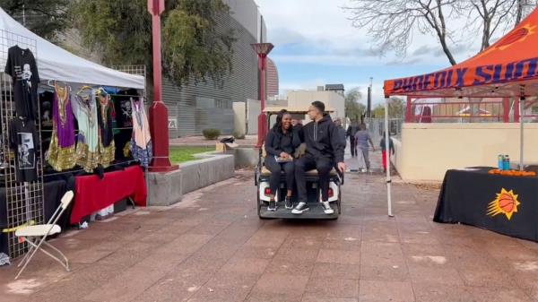 Griner and her wife share a laugh while riding on the back of a golf cart at the event celebrating Dr. King's 94th birthday. 