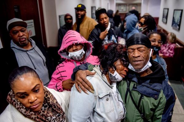 Latryna Sims, partner of Calvin Munerlyn, center, cries on the shoulder of his uncle Ramon Munerlyn, as the family celebrates the sentencing of the three defendants outside the courtroom Tuesday.  