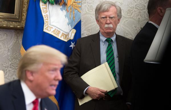 Bolton looks on as Trump speaks.