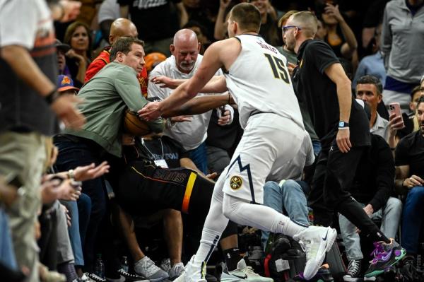 Nikola Jokic reaches for the ball from Mat Ishbia.