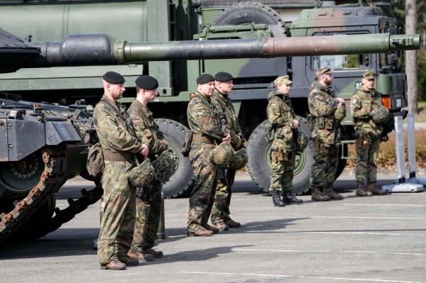 German soldiers stand at a Leopard tank.