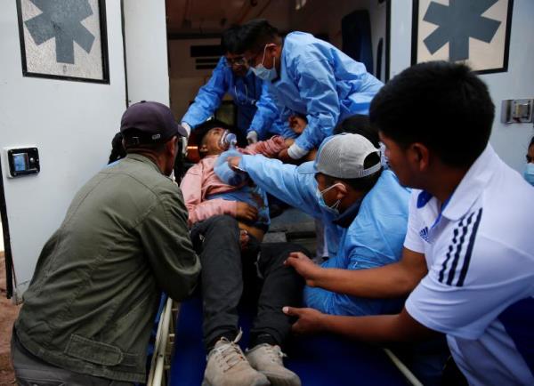 Demo<em></em>nstrators assist an injured man during a clash with security forces near the Juliaca airport, in Juliaca, Peru on Jan. 9, 2023.