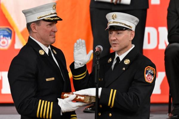 Hodgens swearing in Deputy Assistant Chief Brian Cordasco.