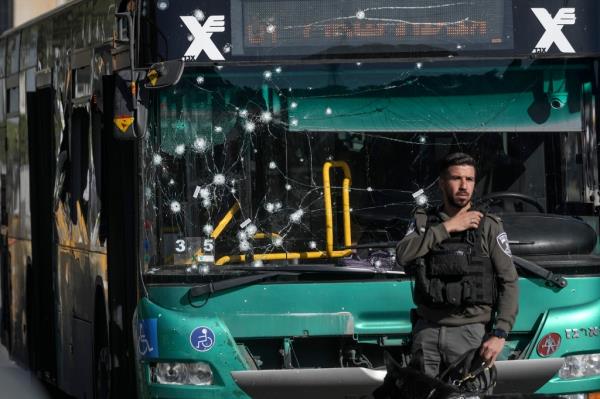 Israeli police inspect the scene of an explosion at a bus stop in Jerusalem, Wednesday. A bus is seen damaged by nails. 