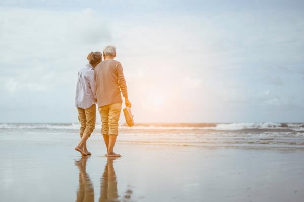 Senior couple walking on the beach.