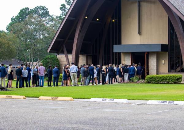 A winding line of people in suits and black dresses formed outside the church doors as mourners waited to pay their respects