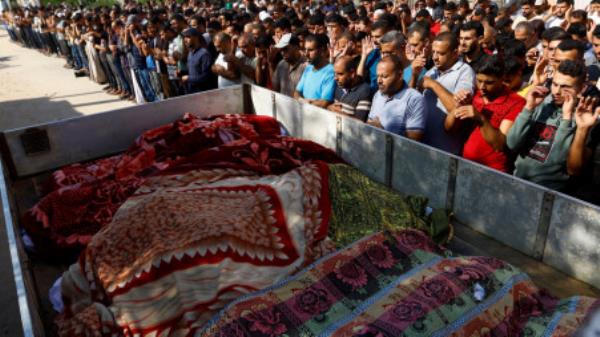 Mourners attend the funeral of Palestinians from Samour family, who were killed in Israeli strikes on their house, in Khan Younis in the southern Gaza Strip October 12, 2023. REUTERS/Ibraheem Abu Mustafa</p>

<p>　　