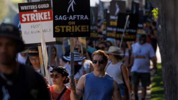 FILE PHOTO: SAG-AFTRA actors and Writers Guild of America (WGA) writers walk the picket line outside Disney Studios in Burbank, California, U.S., July 25, 2023. REUTERS/Mike Blake/File Photo