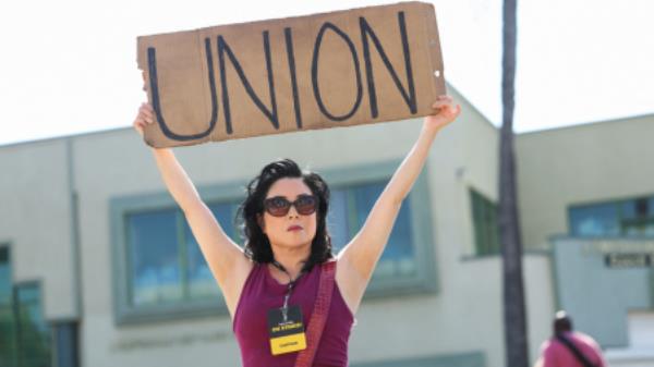Team captain Miki Yamashita holds a sign as she and other SAG-AFTRA members walk the picket line on the 100th day of their o<em></em>ngoing strike, outside Paramount Studios in Los Angeles, California, U.S., October 20, 2023. REUTERS/Mario Anzuoni