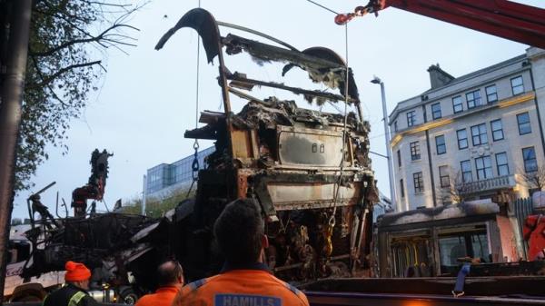 A burned out Luas is removed from the scene