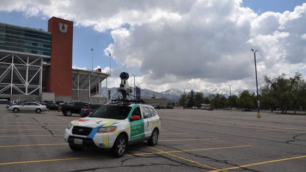 A car with Google logos on it, with a ball on a stuck protruding out the top.