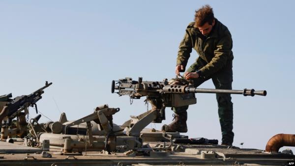 An Israeli soldier checks a weapon in the Israel-annexed Golan Heights near the border with Syria, Dec. 28, 2023. The Israeli army said Saturday that it was carrying out strikes in Syria after two rockets fired from Syria fell into territory under Israel's control.  