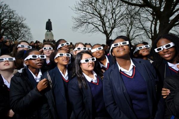 LONDON, UNITED KINGDOM - MARCH 20: Local school kids wear protective glasses to watch a partial solar eclipse from Greenwich park on March 20, 2015. A partial eclipse of varying degrees was visible, depending on weather conditions, across most of Europe, northern Africa, northwest Asia and the Middle East, before finishing its show close to the North Pole. (Photo by Joseph Okpako/Getty Images)