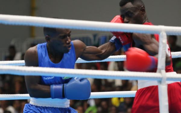 Pacific Games boxing round of 16:  Solomon Islands boxer Maximillian Makana’s (blue) left hook featured prominently in his 4-1 split decision win over Floyd Kunnopi from Papua New Guinea. Friendship Hall Ho<em></em>niara 27 November 2023 credit RNZ Pacific/Koroi Hawkins