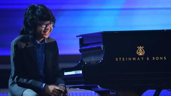 Twelve-year-old jazz pianist Joey Alexander smiles as the audience cheers after his performance at the 2016 Grammy Awards.