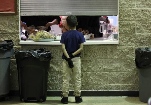 Isaac Guerrero, 8, watches as his parents carve a turkey inside a kitchen space during a potluck Thanksgiving dinner at St. Agatha Catholic Church in Chicago on Nov. 21, 2023. 