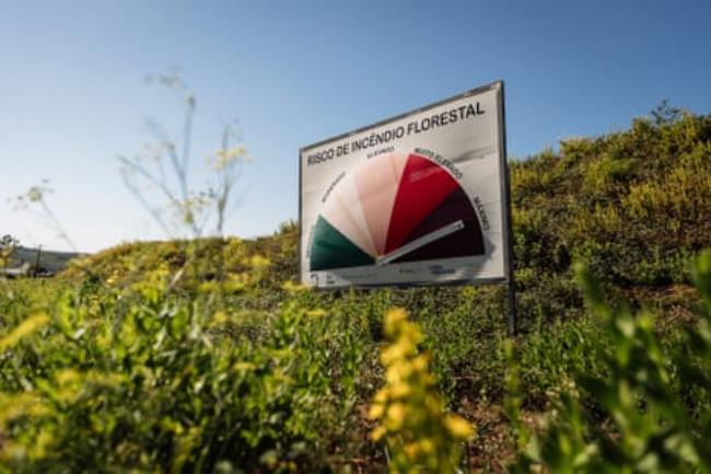 A sign displays the wildfire risk level, which peaks in October