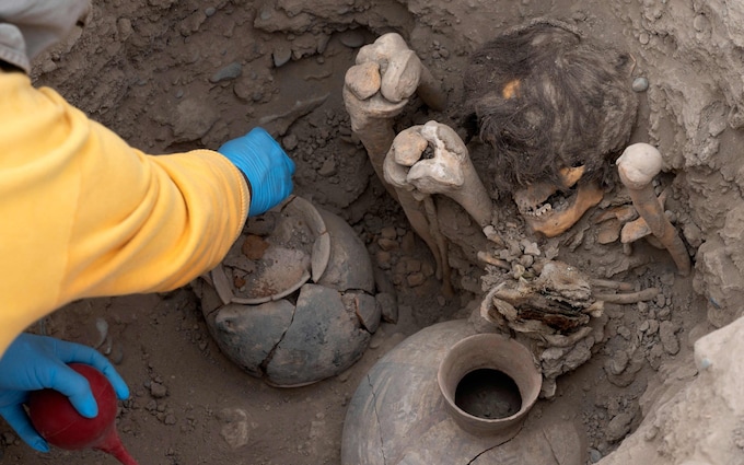 A worker uncovers a mummy belo<em></em>nging to the pre-Inca Ychsma culture buried in a shallow funeral chamber on an ancient sanctuary