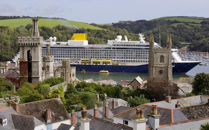 The ship dwarfs the surrounding hilltops of Fowey
