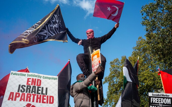 Pro-Palestine protesters wave the black 'call to prayer' flag in Lo<em></em>ndon which has now been co-opted by militant groups