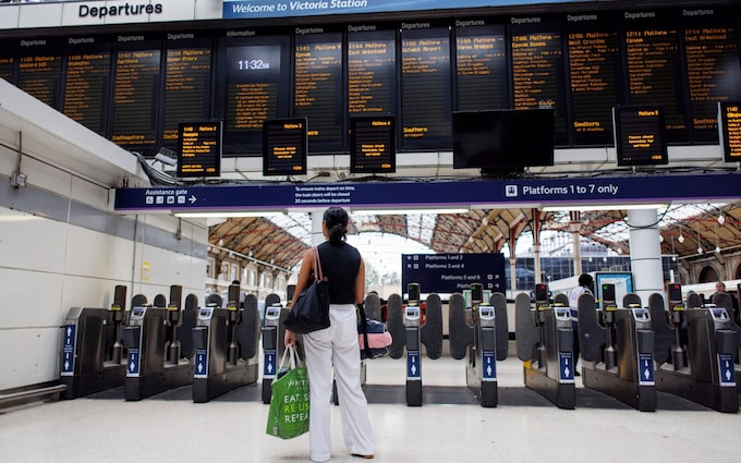 Passengers wait for train services at Victoria Station during strikes