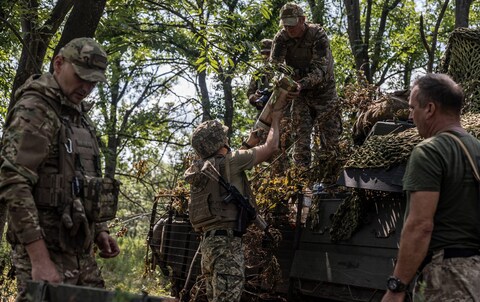 Ukrainian soldiers transport shells into a tank on the Bakhmut front line