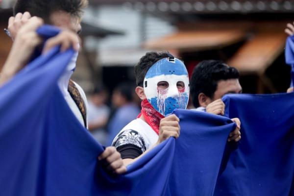 A masked demo<em></em>nstrator attends a protest outside the Jesuit run Universidad Centroamericana, UCA, demanding the university's allocation of its share of 6% of the natio<em></em>nal budget, in Managua, Nicaragua, Thursday, Aug. 2, 2018. (AP Photo/Arnulfo Franco)