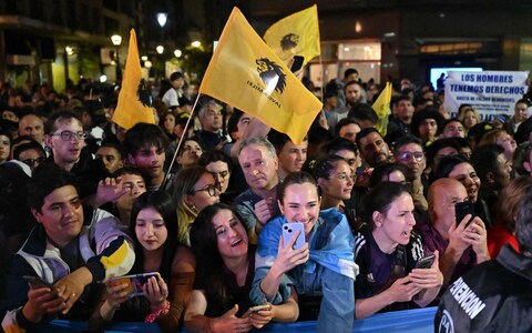 Supporters of Mr Milei wave flags outside his party headquarters