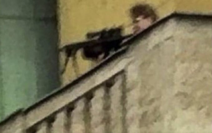 Grainy photographs circulated o<em></em>nline of a man in black clothing wielding an assault rifle on the roof walkway of the Prague university building
