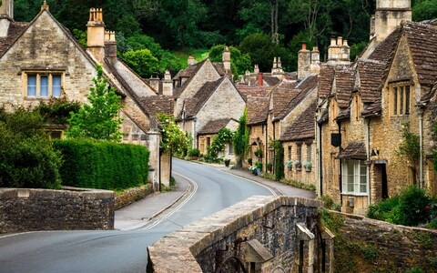 Traditio<em></em>nal English village in the Cotswolds area of southwest England. The cosy little brick cottages line the narrow road, and there is also a quaint bridge spanning a little stream