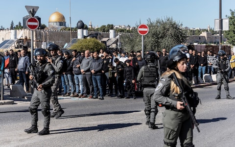 Israeli border police officers stand with weapons in Jerusalem as Muslim Palestinians hold Friday prayers