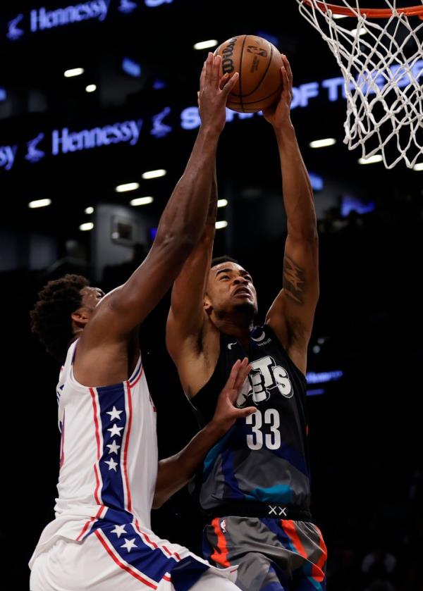 Brooklyn Nets center Nic Claxton (33) is fouled by Philadelphia 76ers center Joel Embiid during the second half of an NBA basketball game, Sunday, Nov. 19, 2023