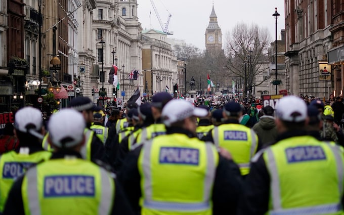 Police follow the end of the march as protesters hold up banners, flags and placards during a demo<em></em>nstration in support of Palestinian people in Gaza