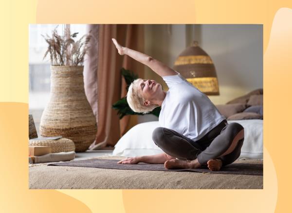 mature woman with short blo<em></em>nde hair stretching in boho bedroom on yoga mat