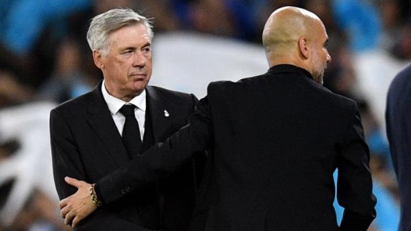 Real Madrid boss Carlo Ancelotti (L) with Manchester City manager Pep Guardiola