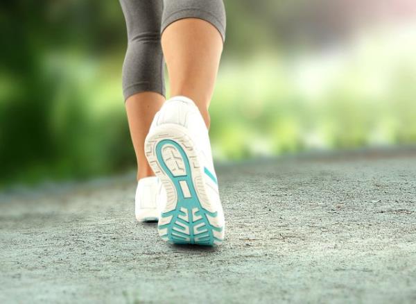 close-up of sneakers, woman walking, co<em></em>ncept of how many daily steps to lose weight