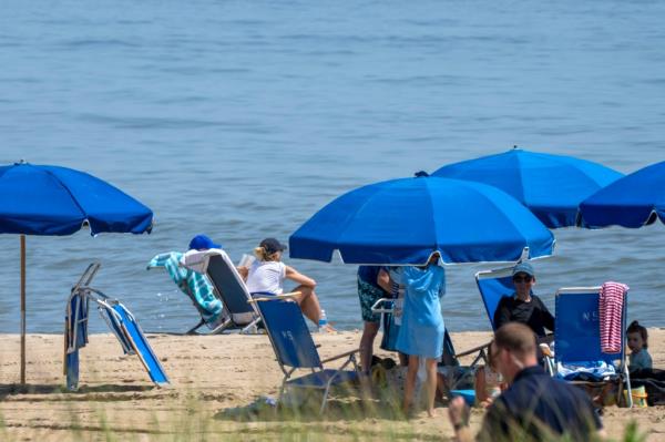 President Joe Biden, seated at left in a blue ba<em></em>seball cap, sits with first lady Jill Biden.